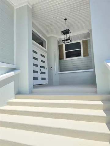 Huge covered patio leading to the entrance with glass accents in the double doors