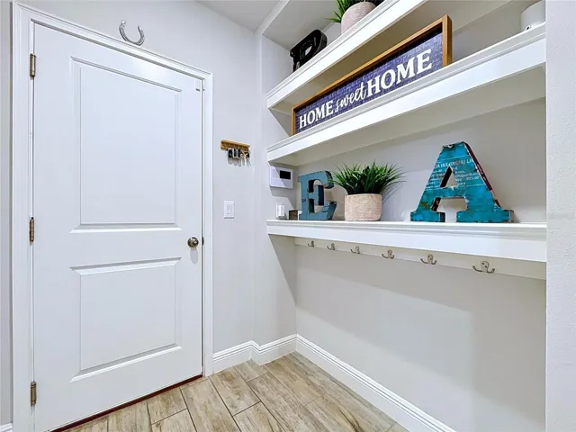 A dedicated laundry room provides exceptional functionality with ample storage shelving, workspace, and room to keep household tasks organized and out of sight