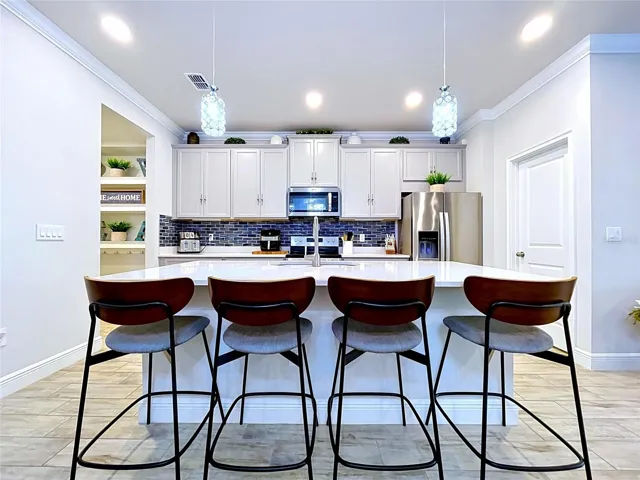 A spacious center island with seating for four serves as the focal point of the kitchen, offering the perfect space for morning coffee, casual meals, or entertaining guests.