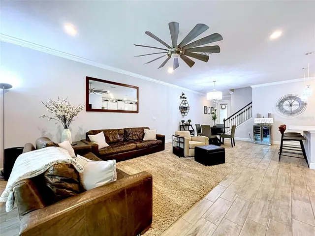 The expansive great room offers plenty of space for comfortable seating and everyday living. Neutral finishes, crown molding, and an open layout create a bright and welcoming atmosphere.