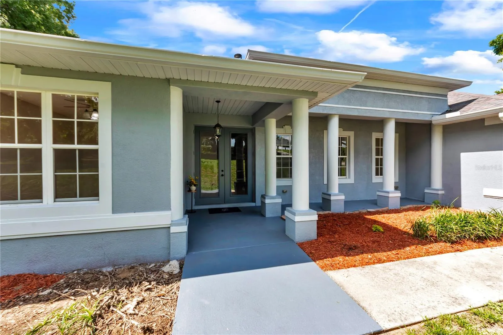 Front Elevation with covered porch leading to beautiful double doors.