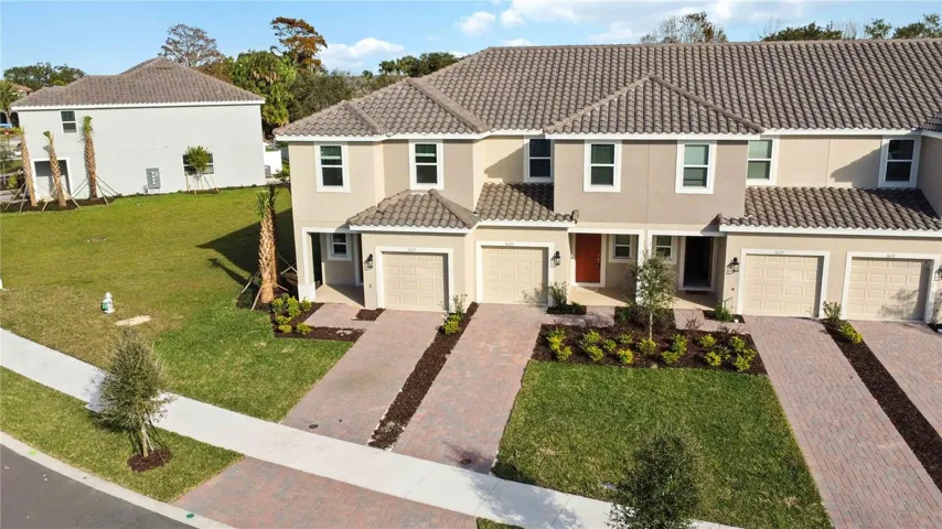 Front Exterior features barrel tile roof, brick paved driveway, front porch and one car garage.