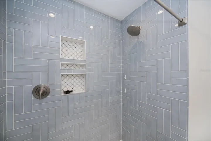 Walk-In Shower Showcasing Designer Tile Work and Custom Niches