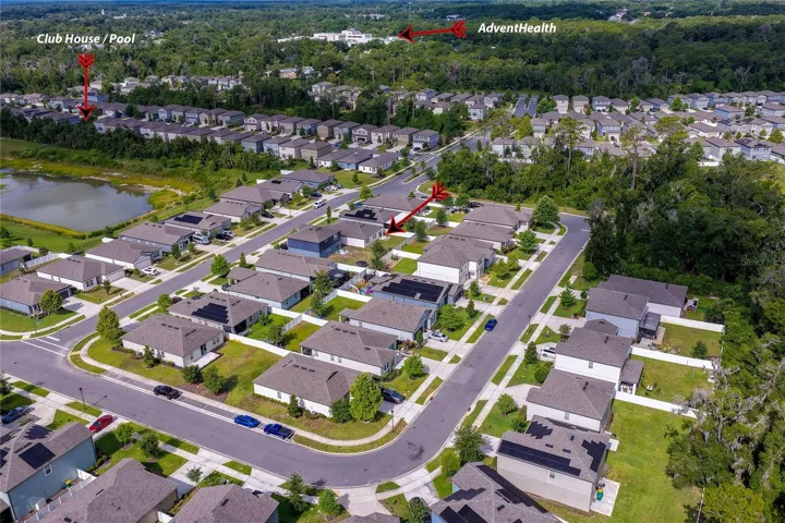 Wide aerial shot highlighting the residential community's proximity to local landmarks, showing the pathway toward AdventHealth and the neighborhood clubhouse.