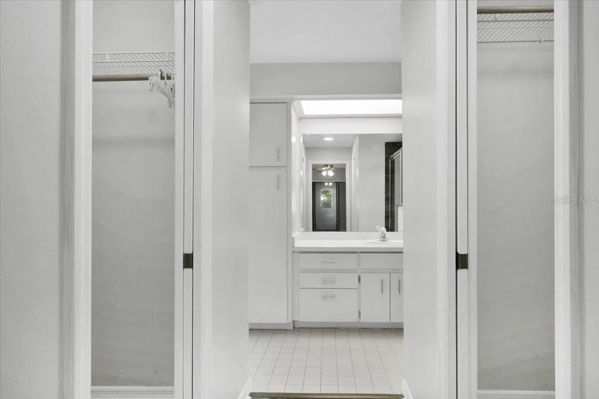 Looking into the primary bathroom with two walk in closets on each side