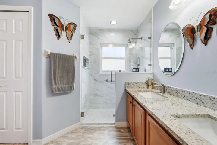 Primary bathroom with zero entry tiled shower with glass enclosure