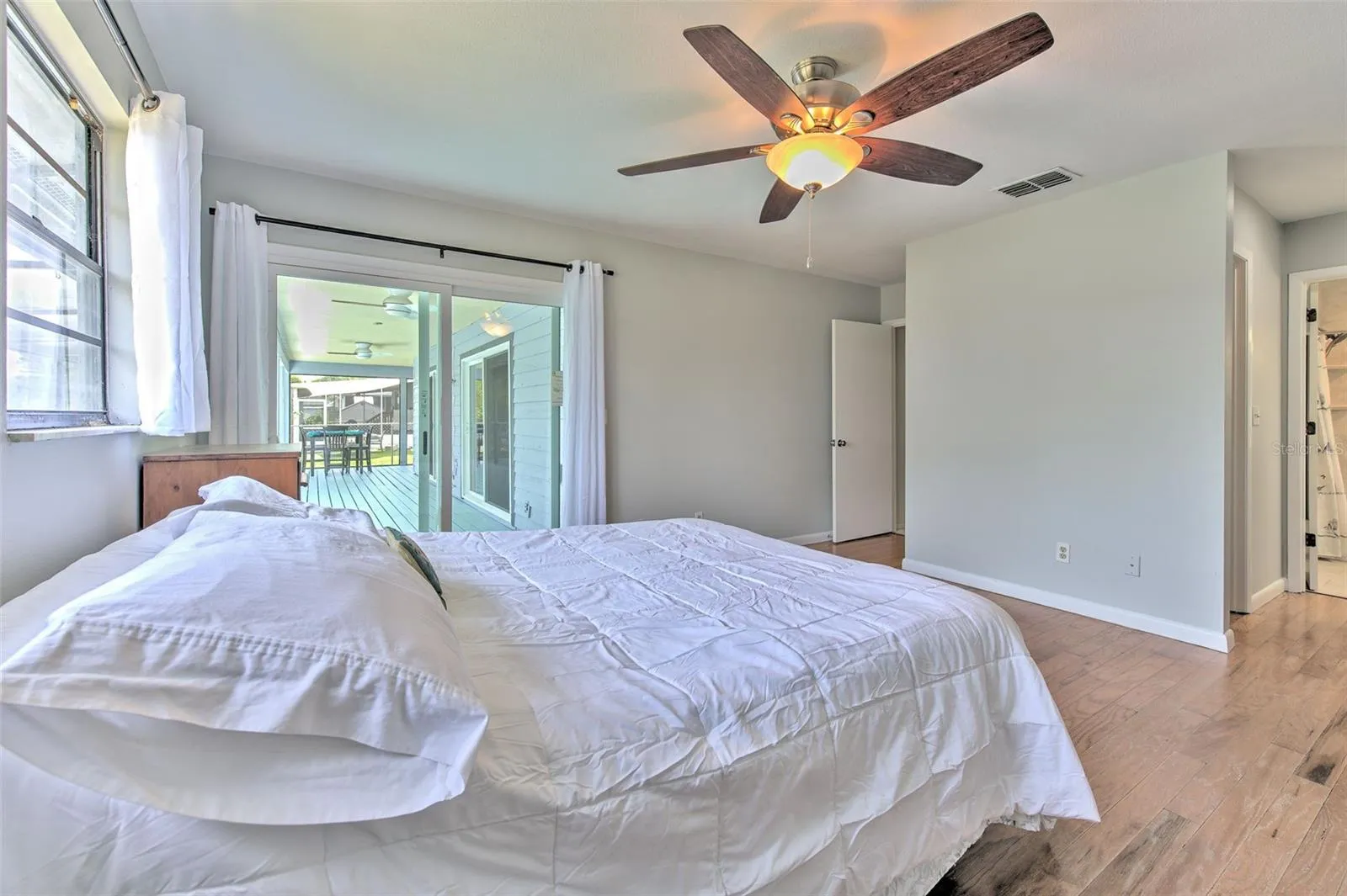 Master Bedroom with Backyard Lake views and slider doors to screened in patio