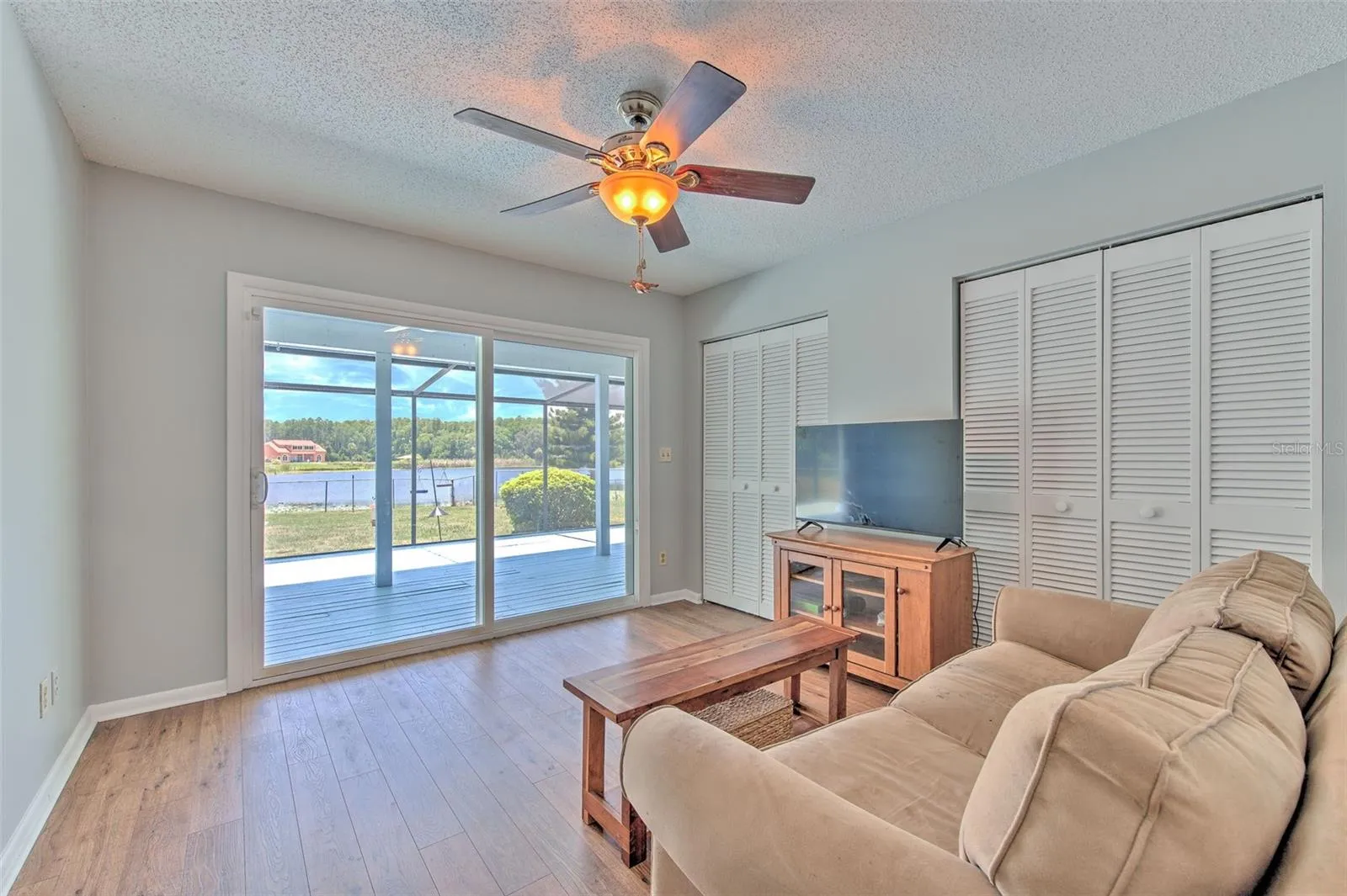 Bedroom 3 with view of Lake and backyard and slider doors to back screened in patio