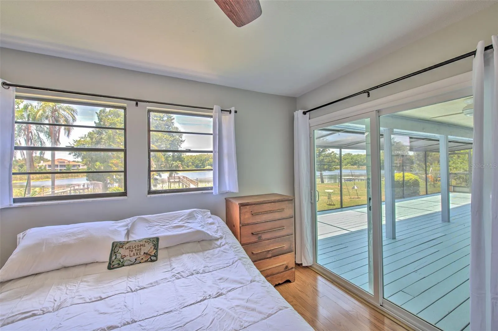 Master Bedroom with Backyard Lake views and slider doors to screened in patio