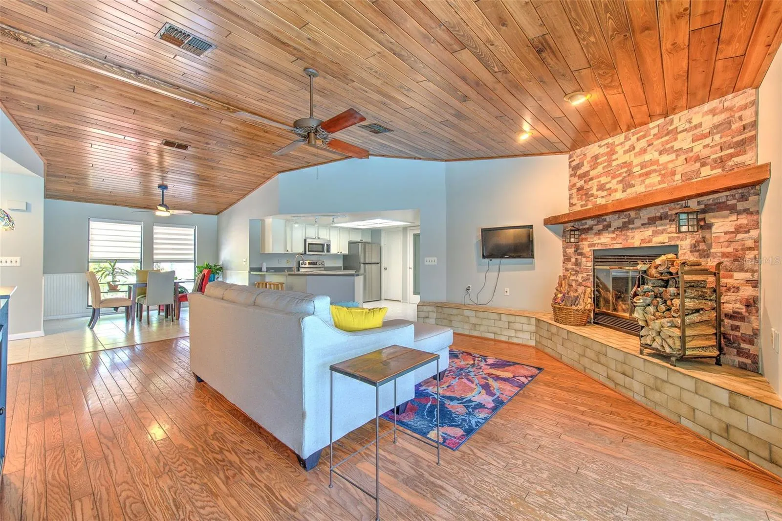 Open concept floor plan. tongue & groove living room ceilings, wood burning fireplace