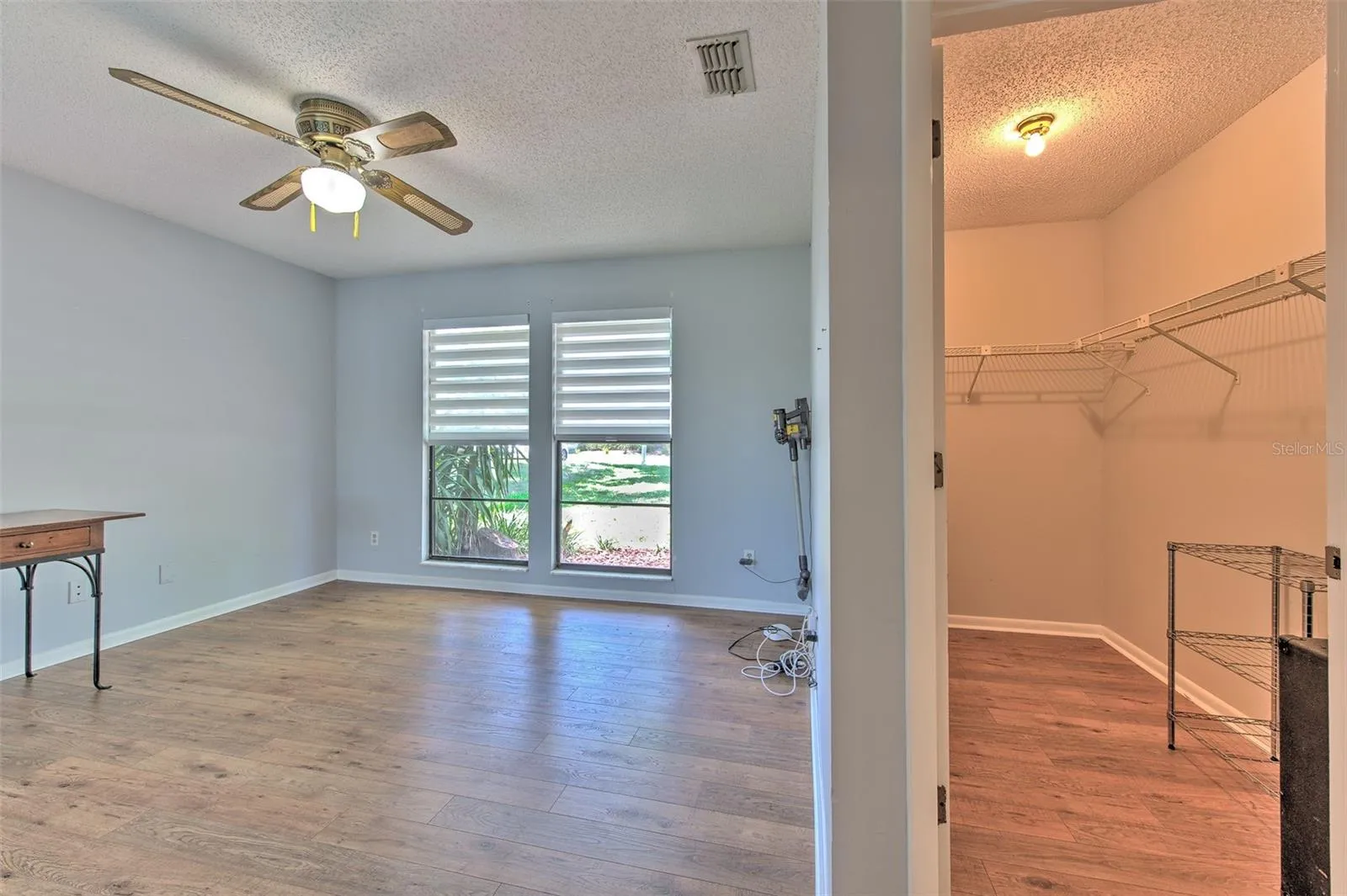 Bedroom 2 with views of front of home & Lake views of back of home, ensuite bathroom, large walk-in closet and slider door to screened in patio