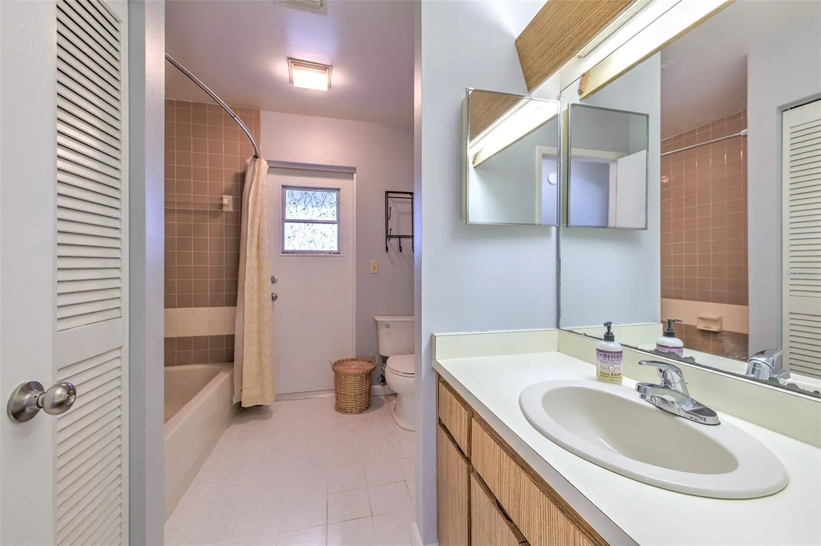 Bathroom with ensuite access to bedroom 2, access to hallway and exit door to screened in patio