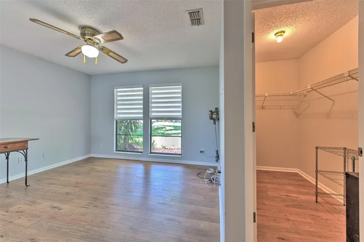 Bedroom 2 with views of front of home & Lake views of back of home, ensuite bathroom, large walk-in closet and slider door to screened in patio