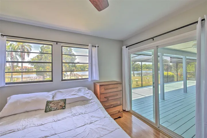 Master Bedroom with Backyard Lake views and slider doors to screened in patio