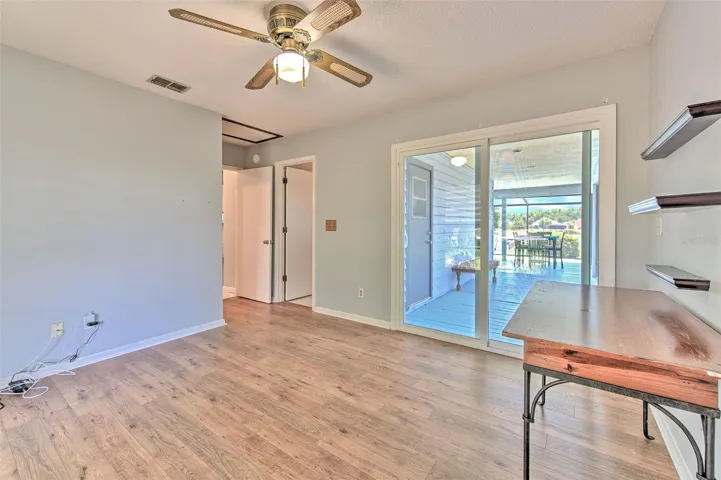 Bedroom 2 with views of front of home & Lake views of back of home, ensuite bathroom, large walk-in closet and slider door to screened in patio