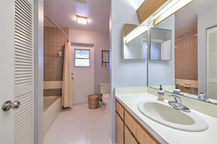Bathroom with ensuite access to bedroom 2, access to hallway and exit door to screened in patio