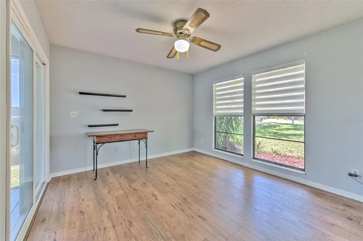 Bedroom 2 with views of front of home & Lake views of back of home, ensuite bathroom, large walk-in closet and slider door to screened in patio
