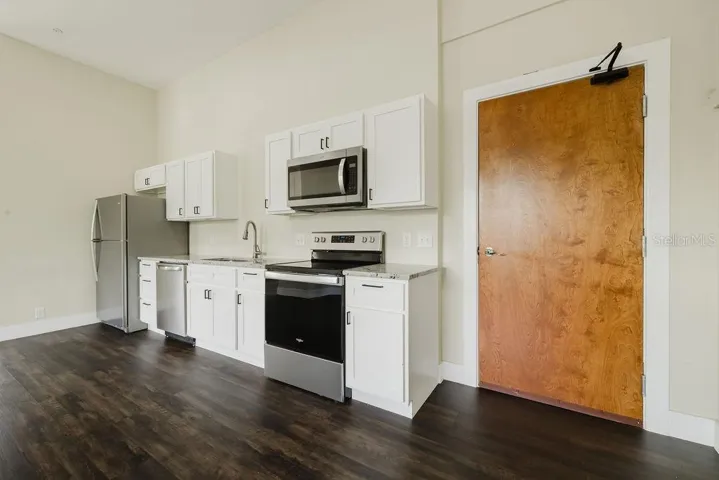 Kitchen with stainless steel appliances, granite countertops, and all wood cabinets.