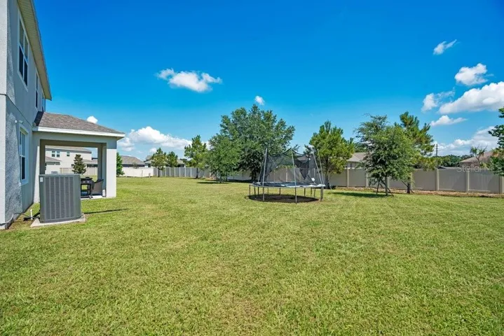 Step outside to the covered patio overlooking the SPACIOUS BACKYARD.