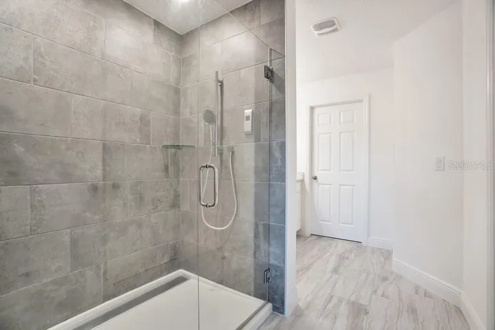 The Primary en suite Bath features a step-in shower with dual showerheads, a private water closet, and a vanity with dual sinks.