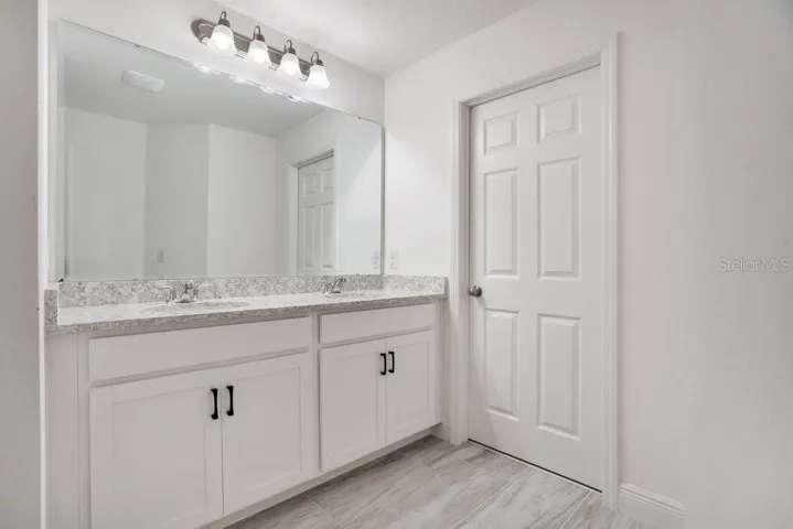 The Primary en suite Bath features a step-in shower with dual showerheads, a private water closet, and a vanity with dual sinks.