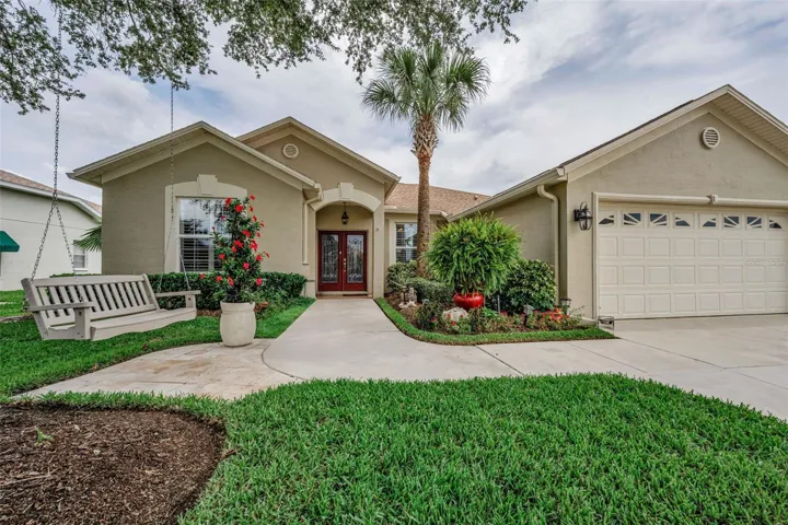Warm & Welcoming approach with a beckoning tree swing overlooking lush landscaping.