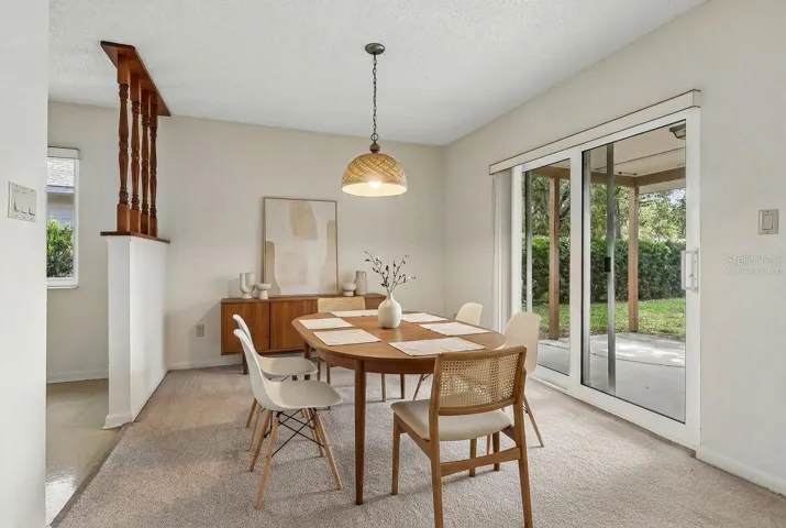 Dining area has sliding glass doors that open to the covered lanai. Virtually Staged.