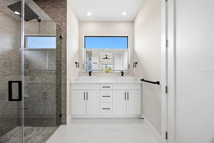 Primary bathroom with dual vanity sinks and walk in shower