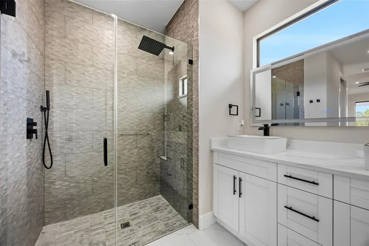 Primary bathroom with dual vanity sinks and walk in shower