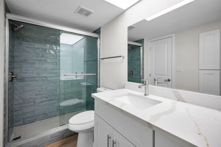 Renovated bathroom with shower, new vanity, toilet and sliding doors
