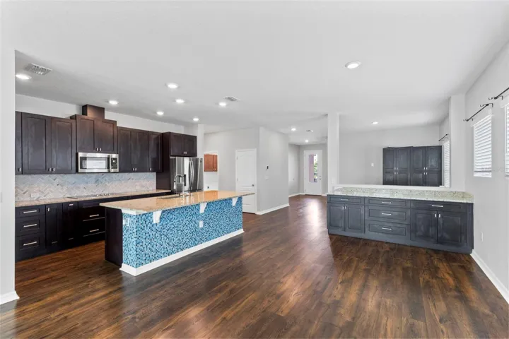 View from family room into dining area & kitchen. Custom cabinets with granite countertops added to dining area for additional storage options & entertaining!