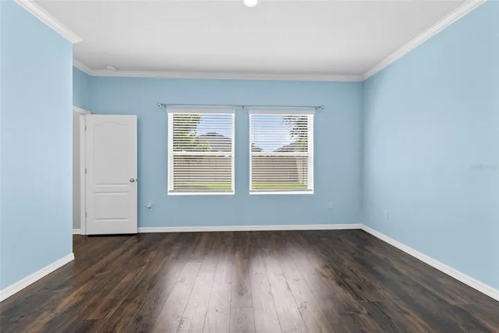 Primary Bedroom features crown molding and new vinyl luxury flooring