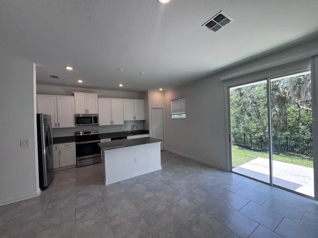 "Gourmet kitchen with stunning forest views. Modern finishes, stainless steel appliances, and seamless transition to nature."