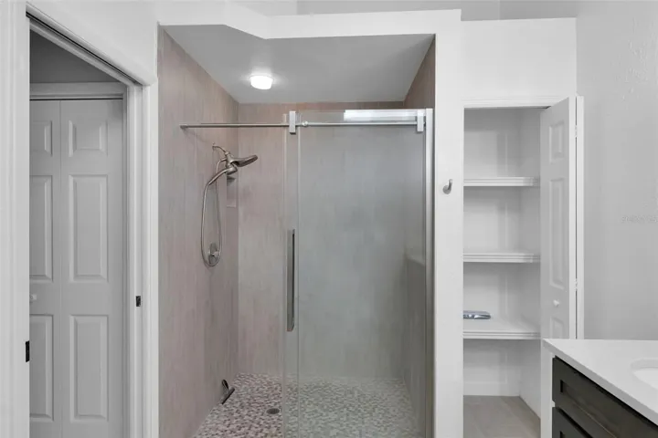 Main bath with stand up shower only, double vanities, granite countertops, linen closet