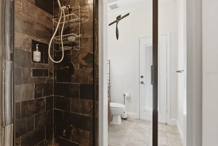 bathroom with walk in shower and  exterior exit to pool area/ or walk way to front
