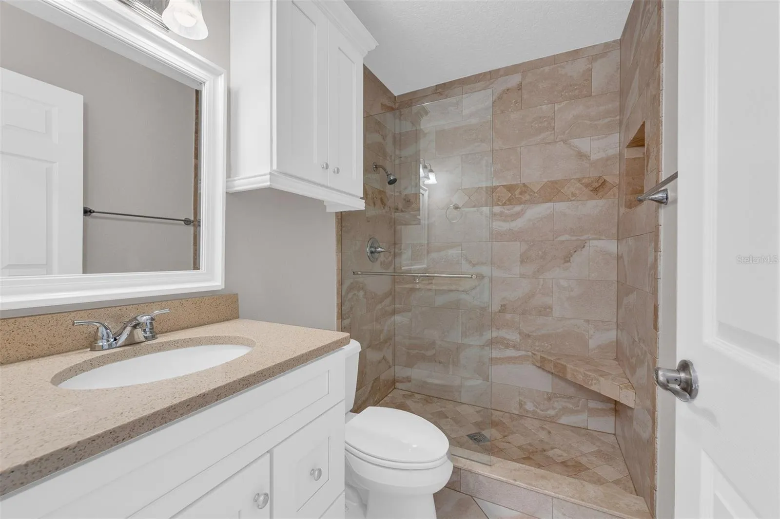 Guest bath with walk-in shower and beautiful travertine tile work