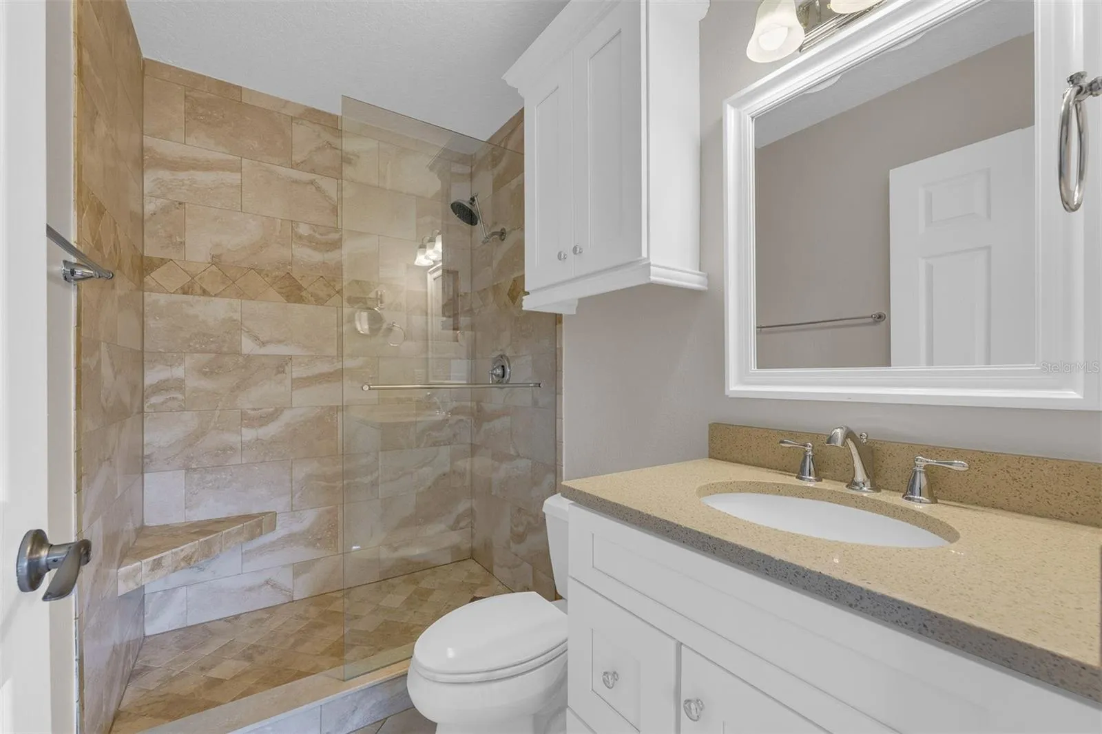 Primary ensuite bathroom with beautiful travertine tile.