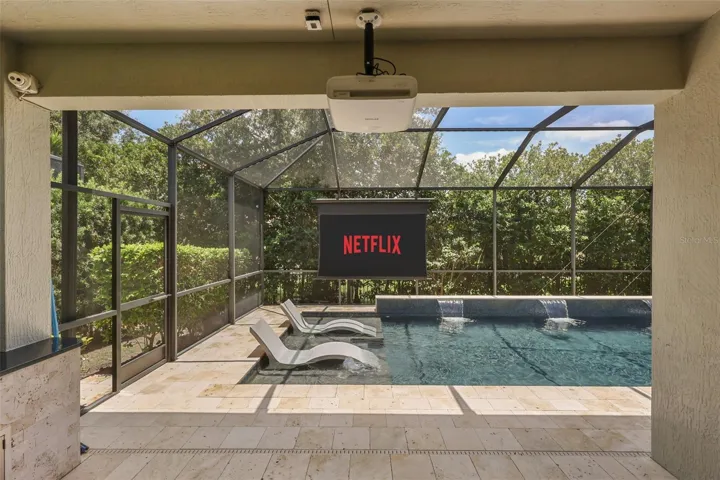 Screened-in pool enclosure with projector and screen