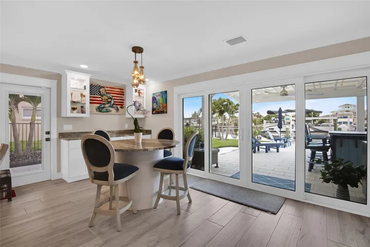 DINING TABLE - WATER VIEWS ABOUND.  DRY BAR - LIGHTED CABINETS -  PGT DOUBLE SLIDERS = NEW - SIDE DOOR TO THE OUTSIDE GRILL AREA
