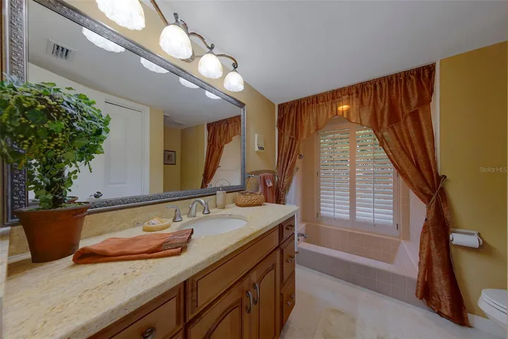 Bathroom 2 features a sunken tub and shower with plantation shutters