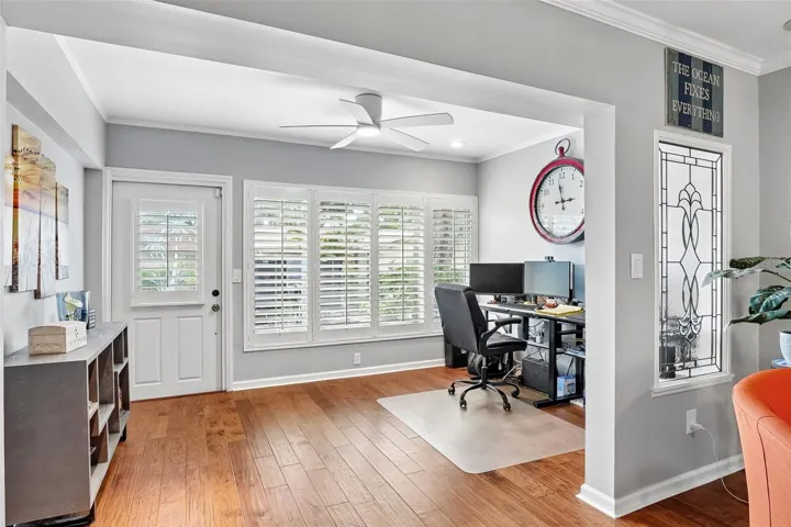 Sunroom / flex space with wall of windows dressed with Key West style plantation shutters is ideal for office, morning coffee, reading or just relaxing.