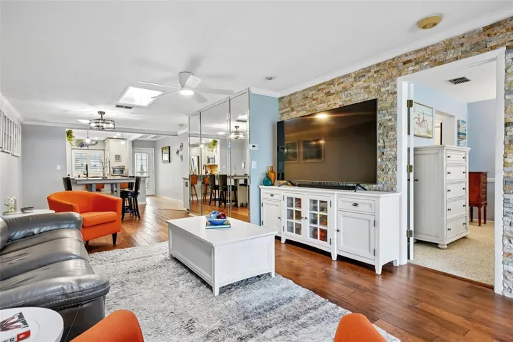 Living room dining room with beautiful engineered hardwood flooring, A travertine accent wall, and LumaDome lighing.