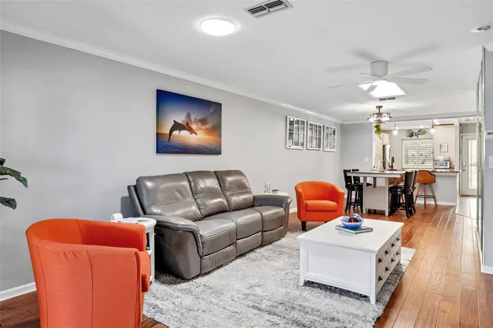 Living room dining room with beautiful engineered hardwood flooring, A travertine accent wall, and LumaDome lighing.