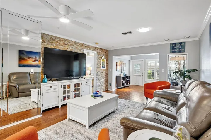 Living room dining room with beautiful engineered hardwood flooring, A travertine accent wall, and LumaDome lighing.