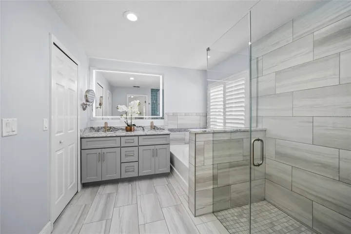 Remodeled primary bath with soaking tub and frameless glass shower