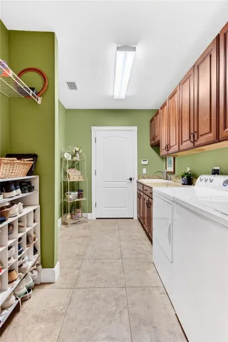 a large laundry room with cabinets & sink