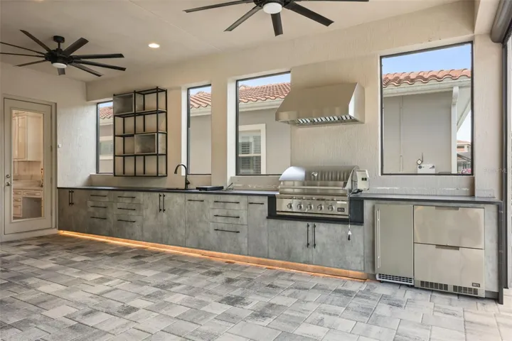 Summer kitchen complete with grill, sink, nugget ice machine, and two drawer refrigerators