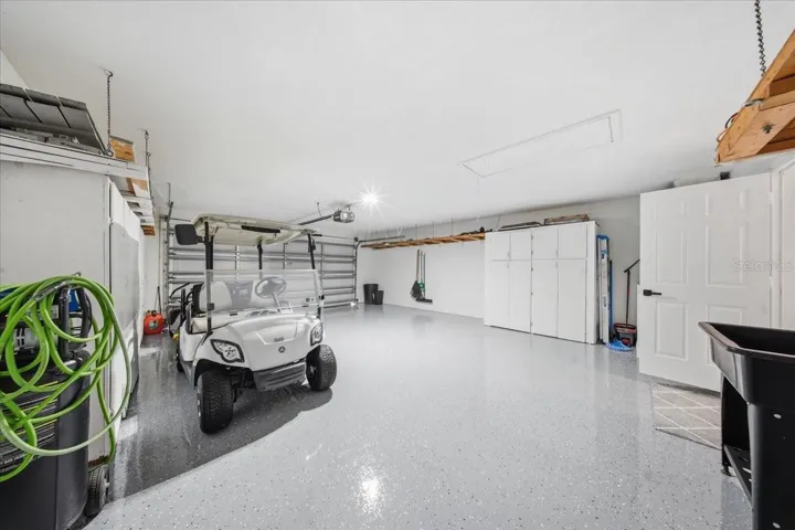 Oversized garage with new epoxy floors and overhead storage.