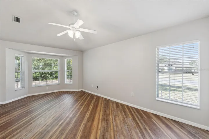 Primary Bedroom with Bay Windows and Vinyl Flooring.