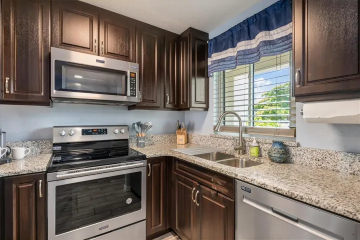 Espresso cabinets, granite countertops and a Maytag stainless steel appliance suite.